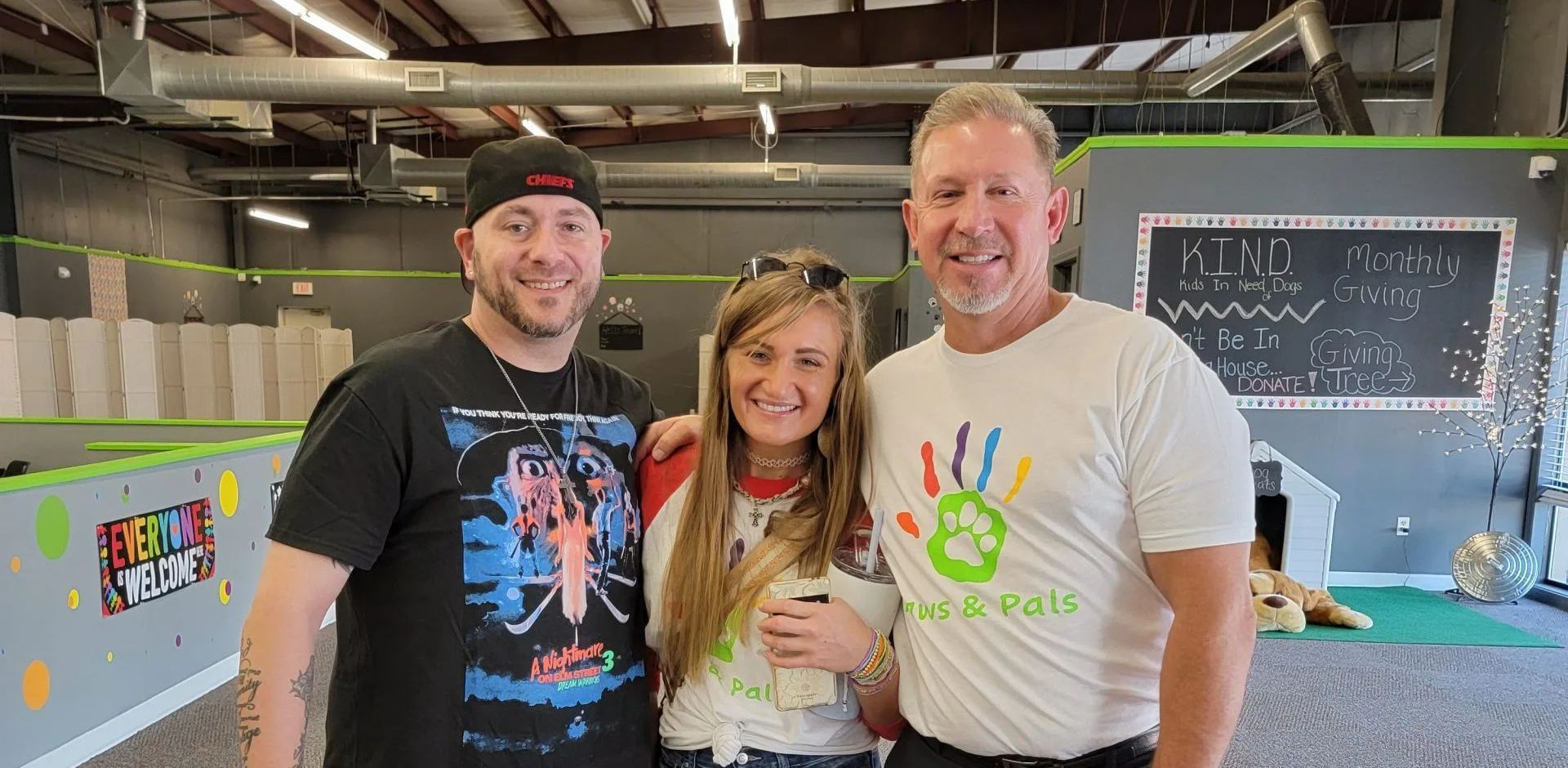 Three people are posing for a picture in a room.