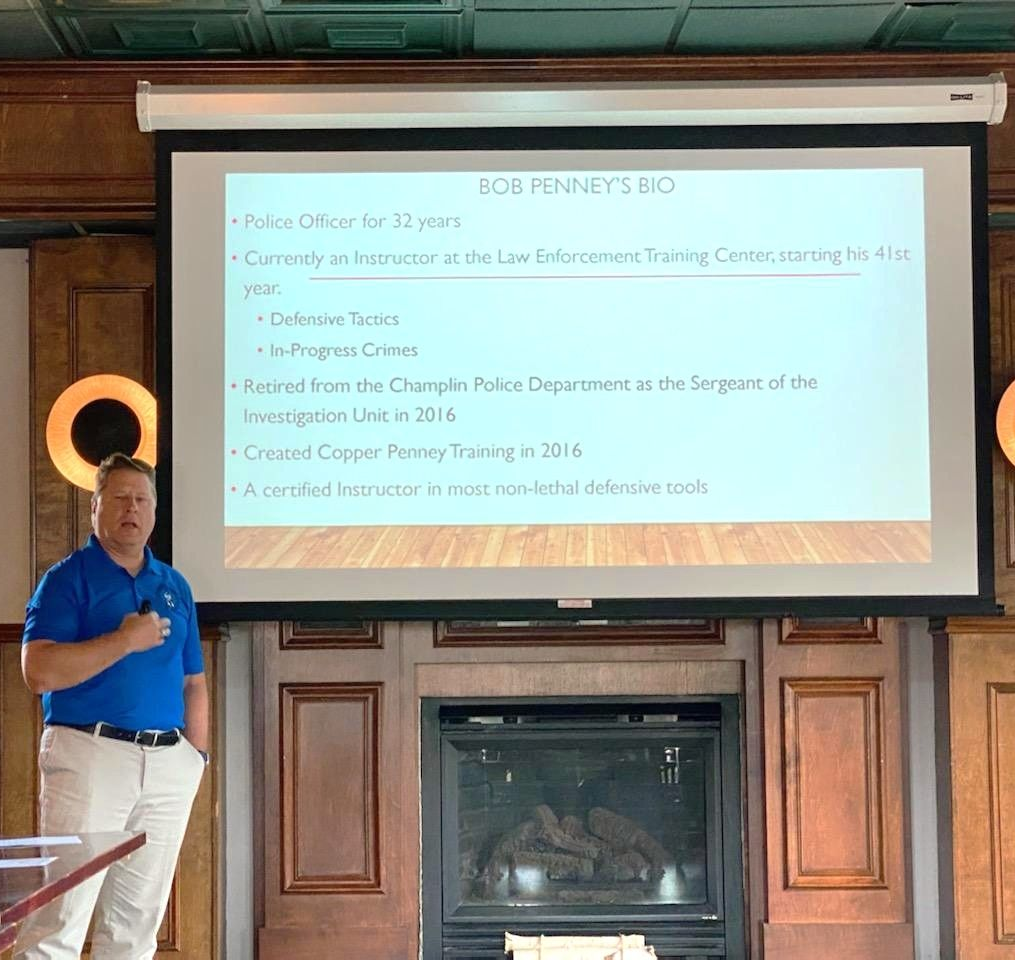 Man in ear protection aiming a handgun at a shooting range target.