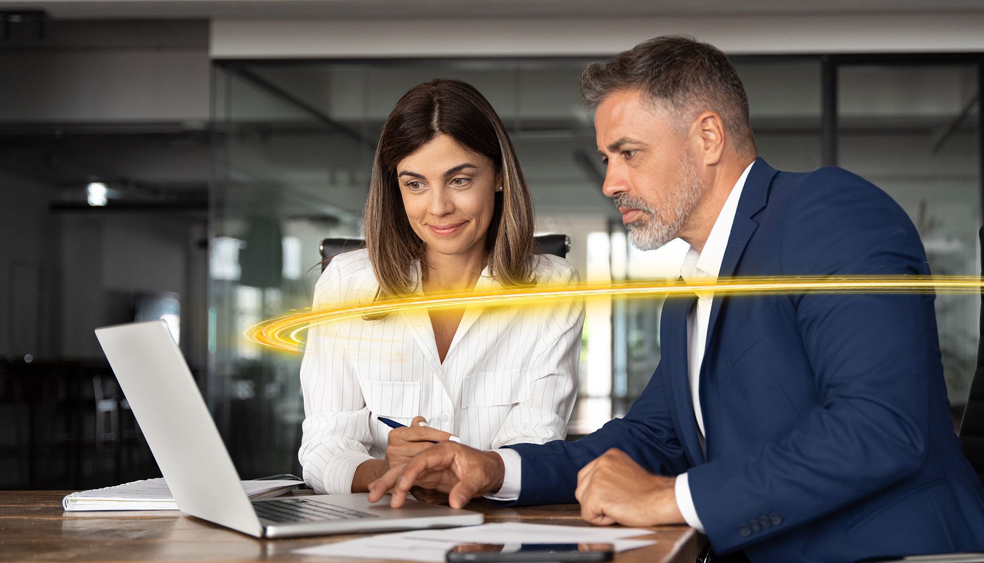 Woman and man looking at a laptop, discussing. Yellow energy line appears across screen.