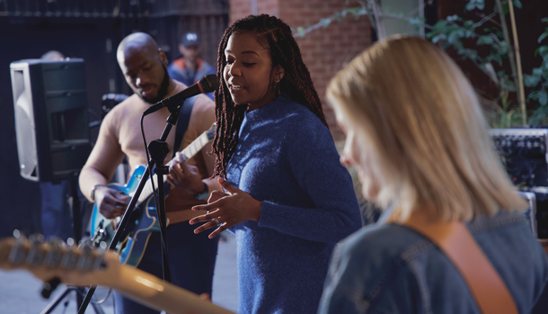 A group of people are playing guitars and singing into microphones.