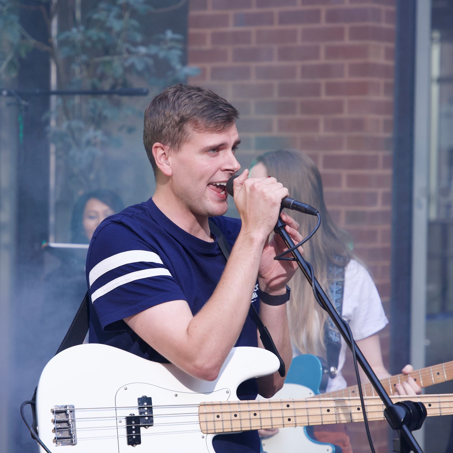 A man singing into a microphone while playing a guitar