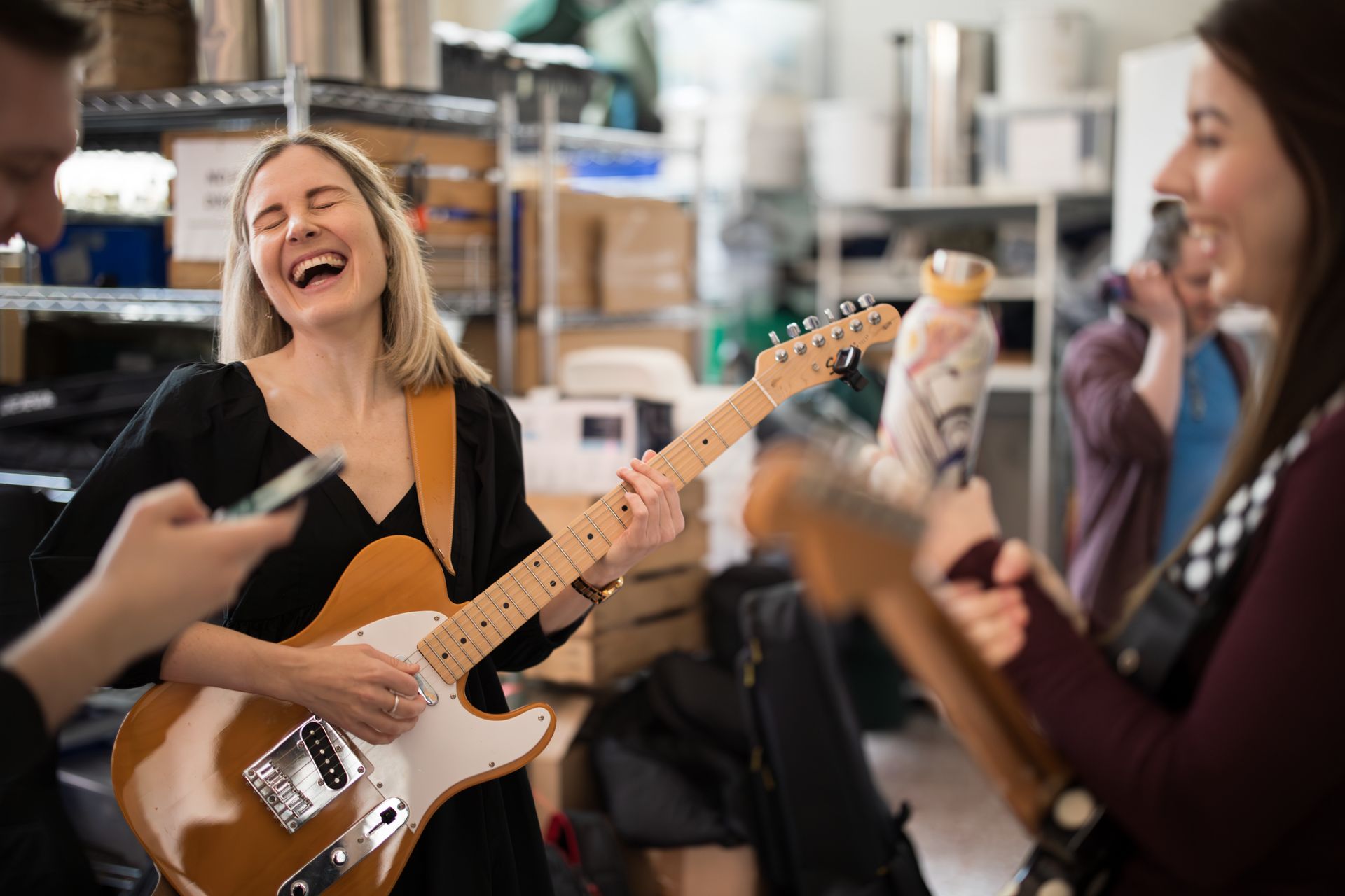 A group of people are playing guitars in a room.