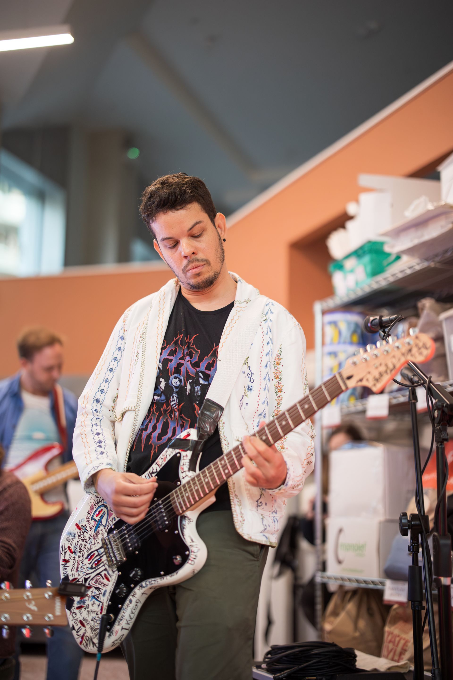 A man is playing a guitar in a room.