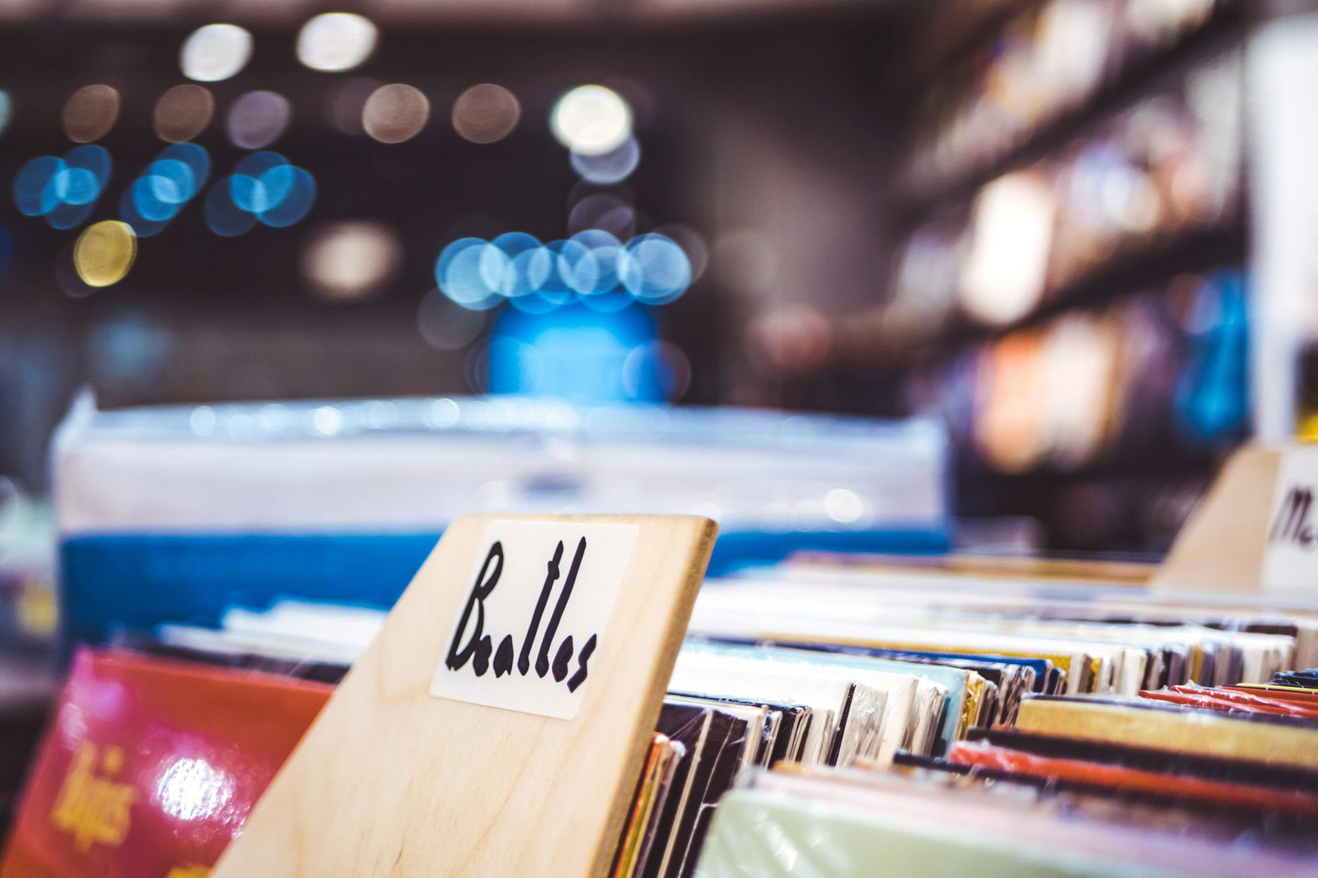 A wooden shelf filled with The Beatles records in a record store.