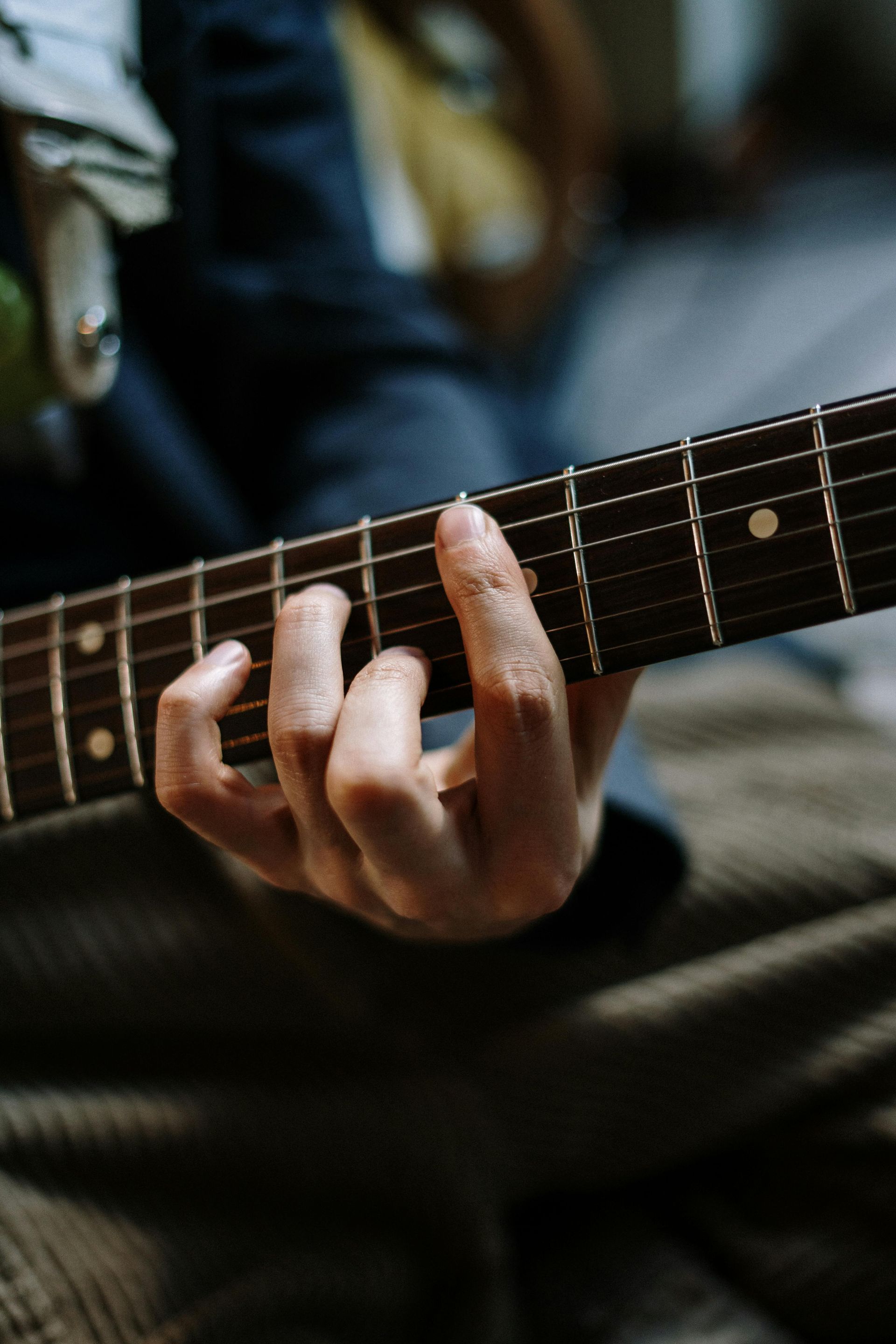 A close up of a person playing an electric guitar.