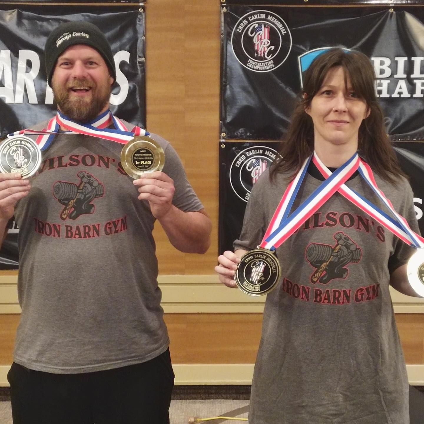 Two people with medals, wearing gray shirts with 