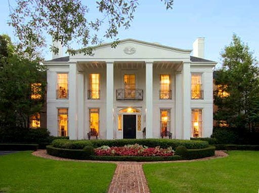 A large white house with a brick walkway leading to it