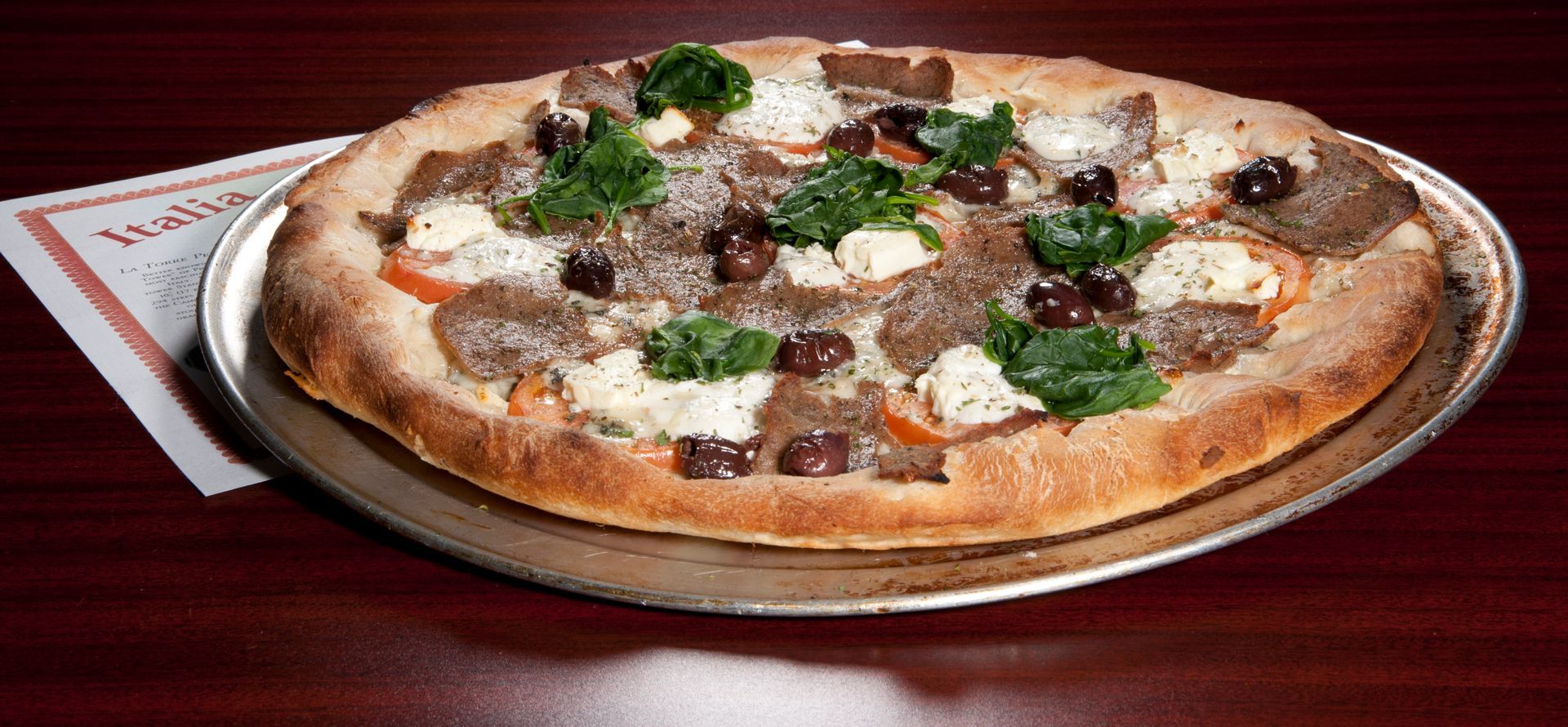 Pizza with toppings on a silver tray.