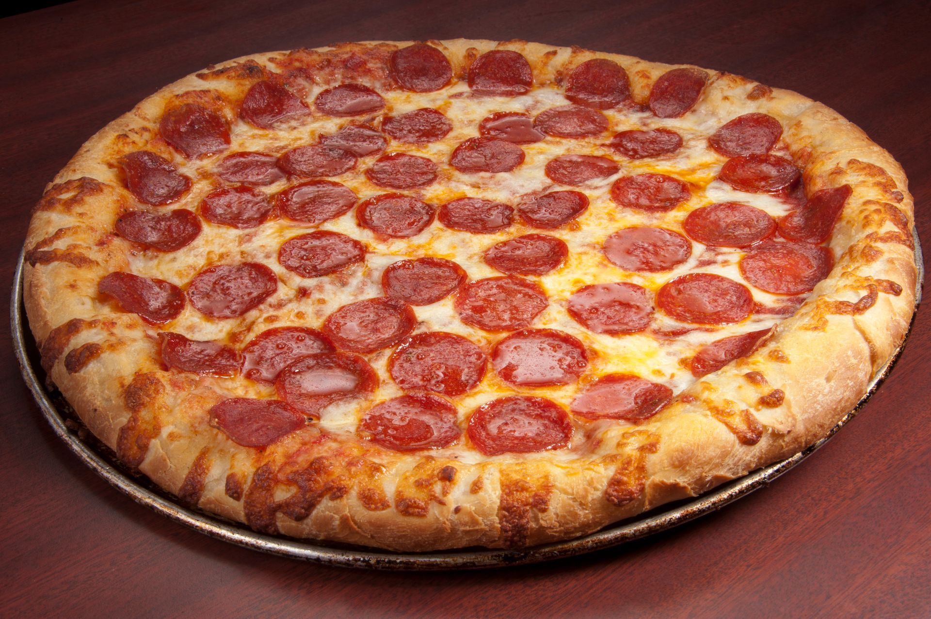 Pepperoni pizza on a metal pan.