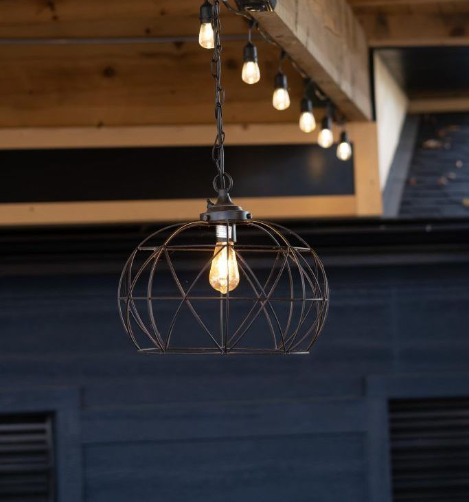 A hanging light with a light bulb inside of it