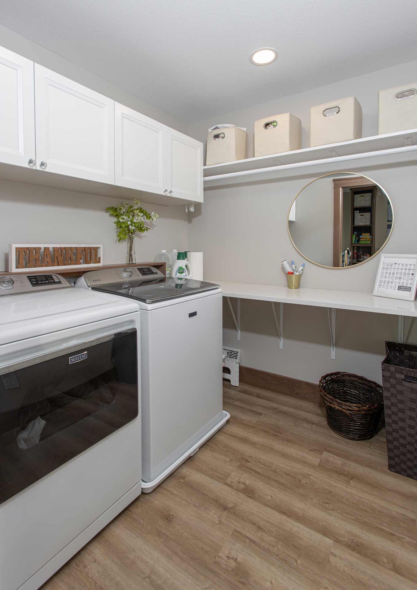 A laundry room with a washer and dryer and a mirror.