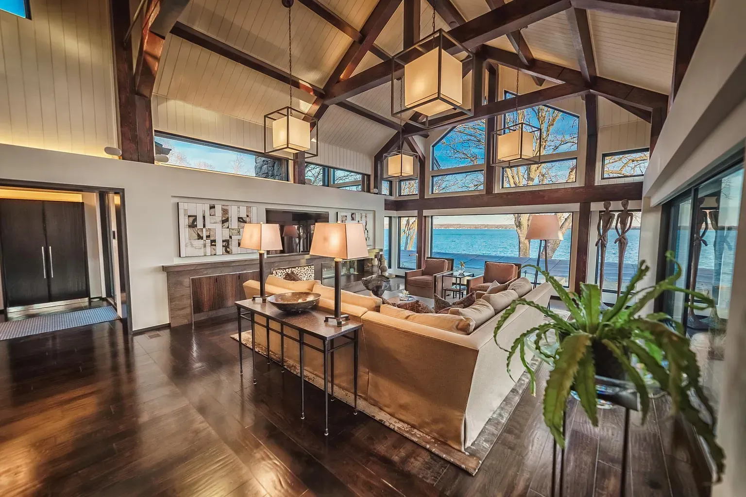 A living room with a lot of furniture and a large window overlooking the ocean.