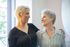 Two women are standing next to each other and smiling.