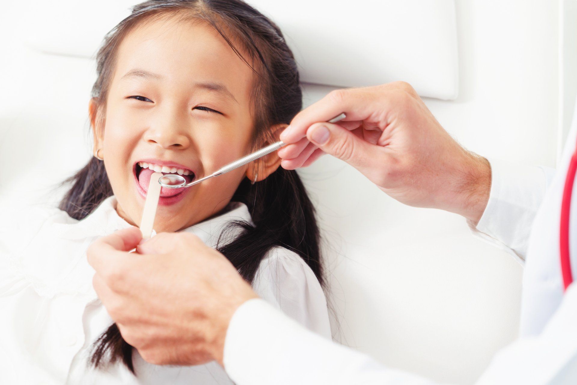 Pediatric Dentistry — Dentist Examining Child Teeth in Statesville, NC