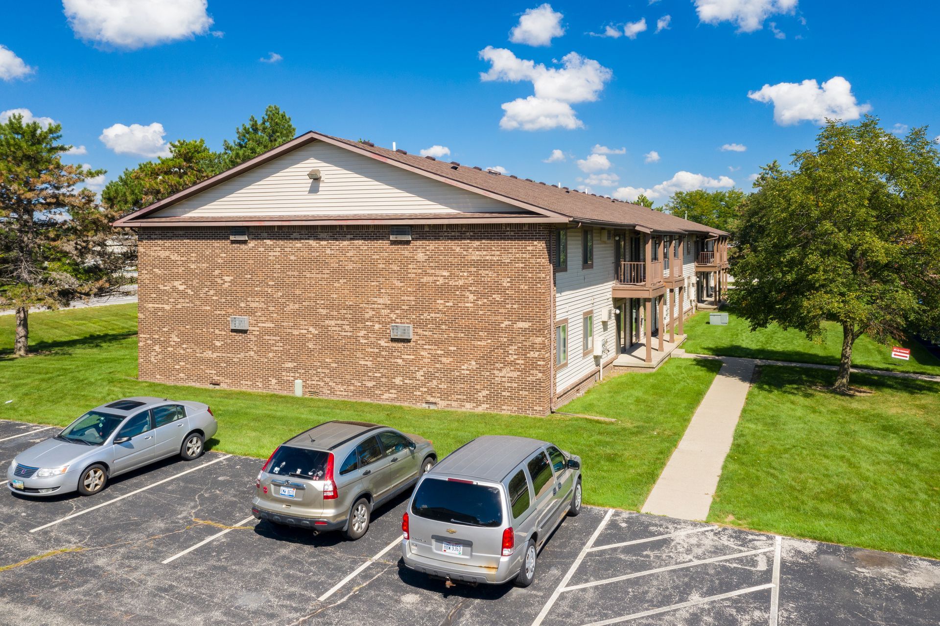 Photo of a two-story building with a parking lot to the side of it