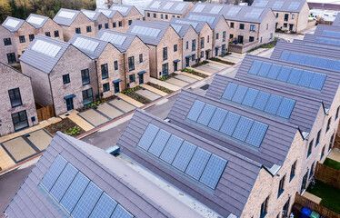 An aerial view of a row of houses with solar panels on the roofs.