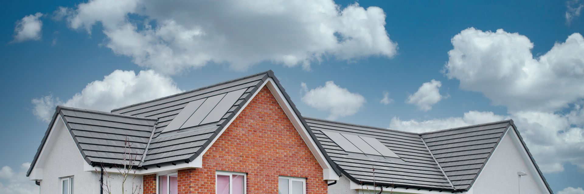 A brick house with a solar panel on the roof.