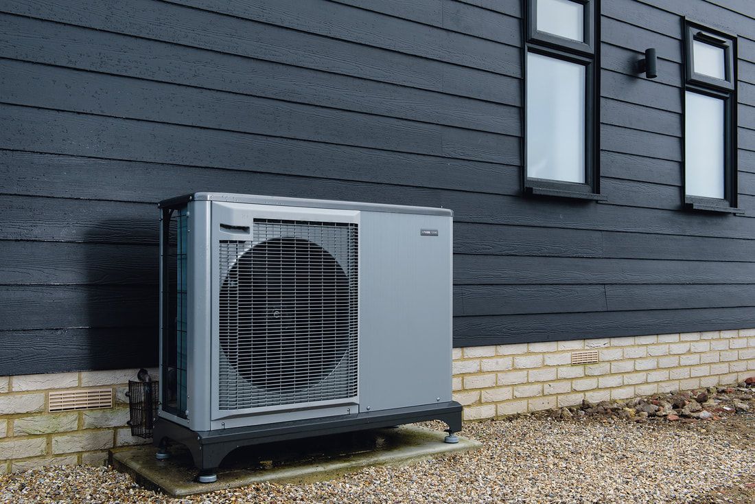 A large air conditioner is sitting on the side of a building.