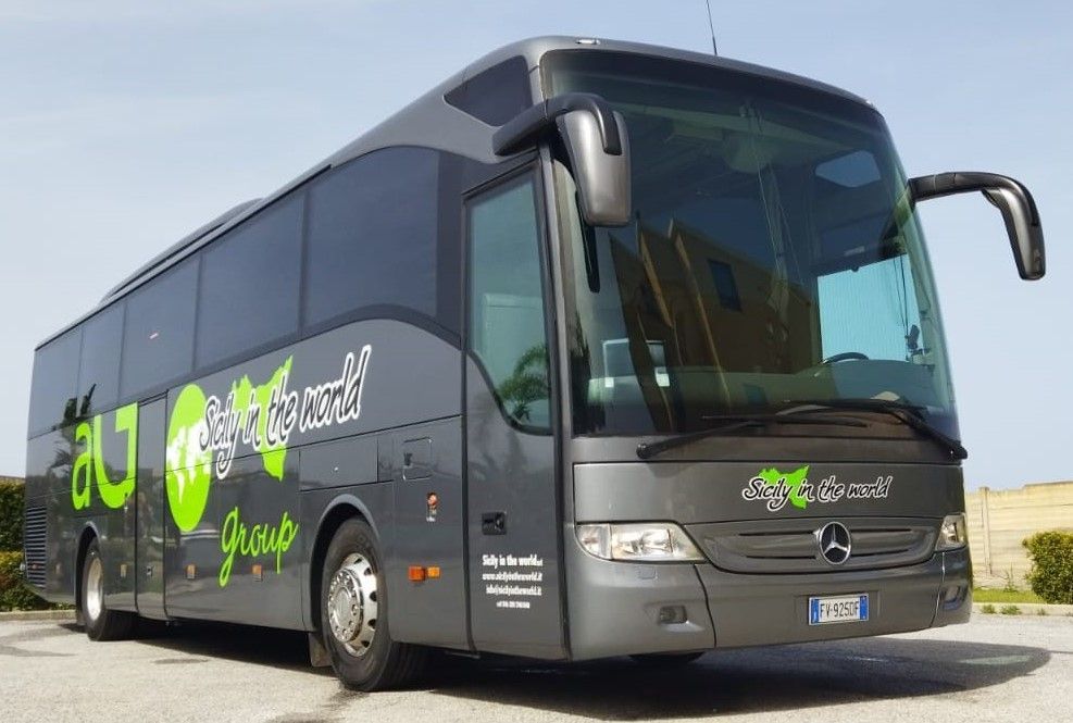 Un furgone nero è parcheggiato su una strada acciottolata di fronte a un edificio