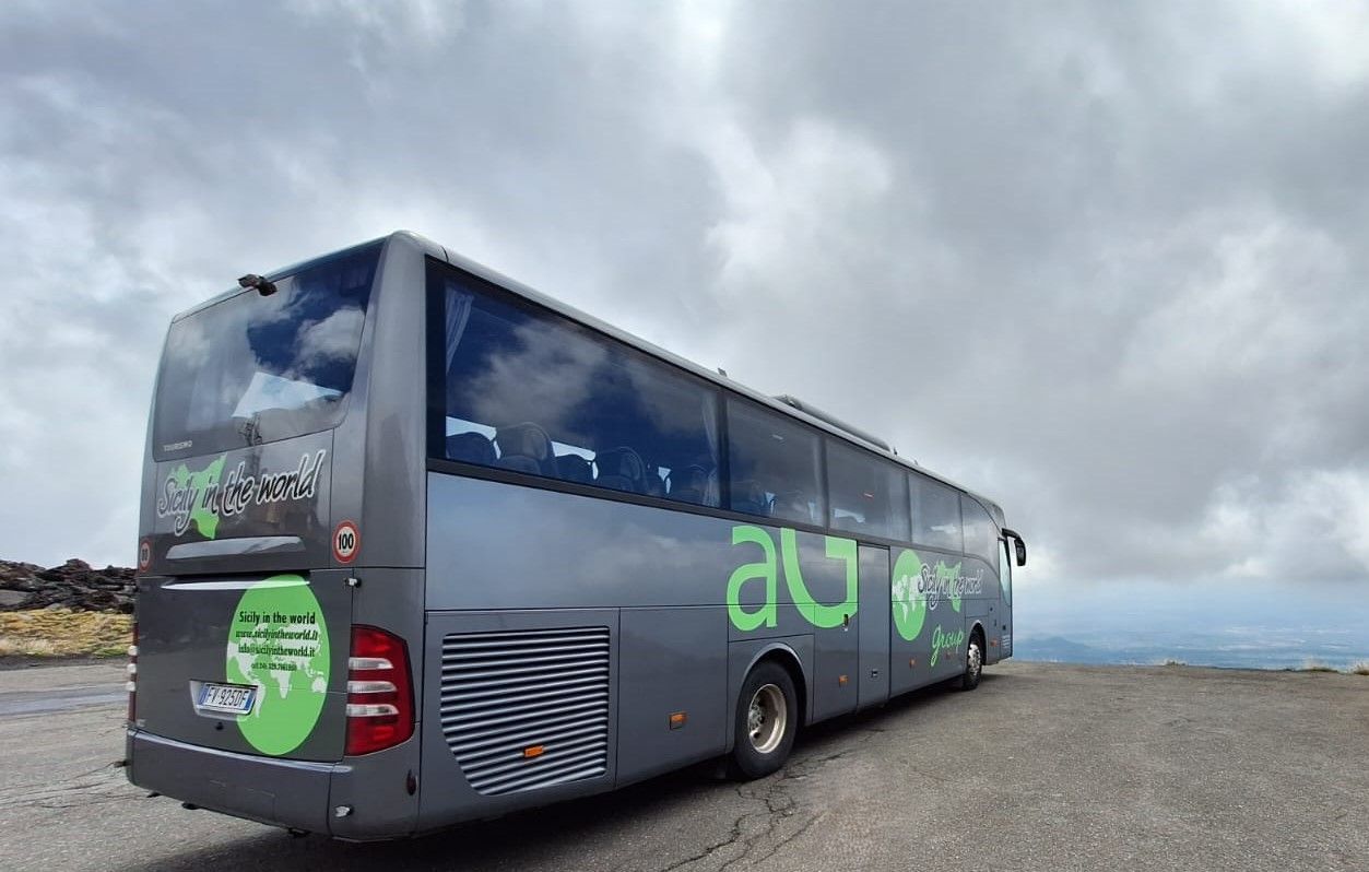 Un autobus è parcheggiato sul ciglio della strada di fronte a un edificio.
