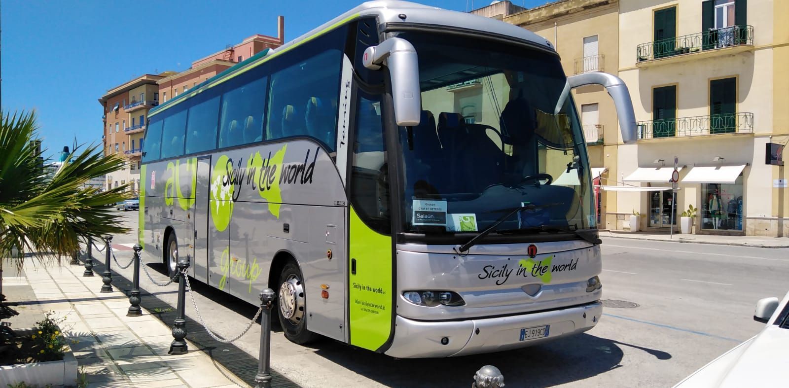 Un autobus è parcheggiato sul ciglio della strada di fronte a un edificio.