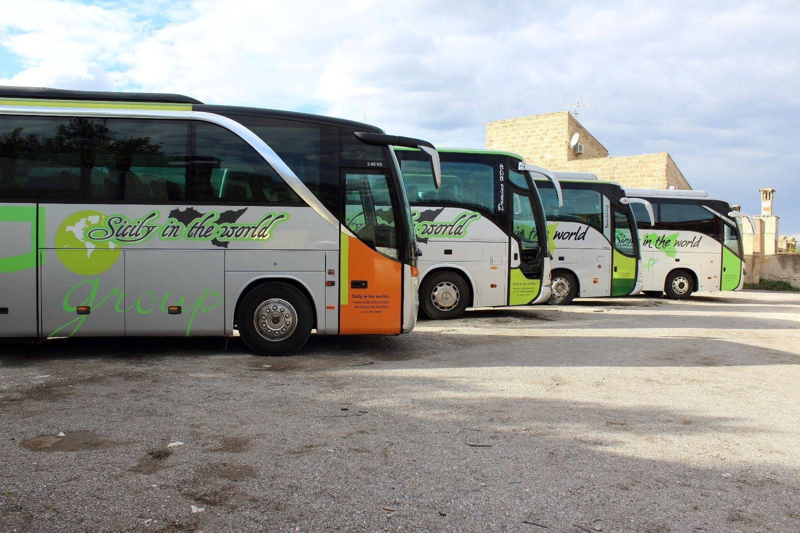 Una fila di autobus è parcheggiata in un parcheggio.