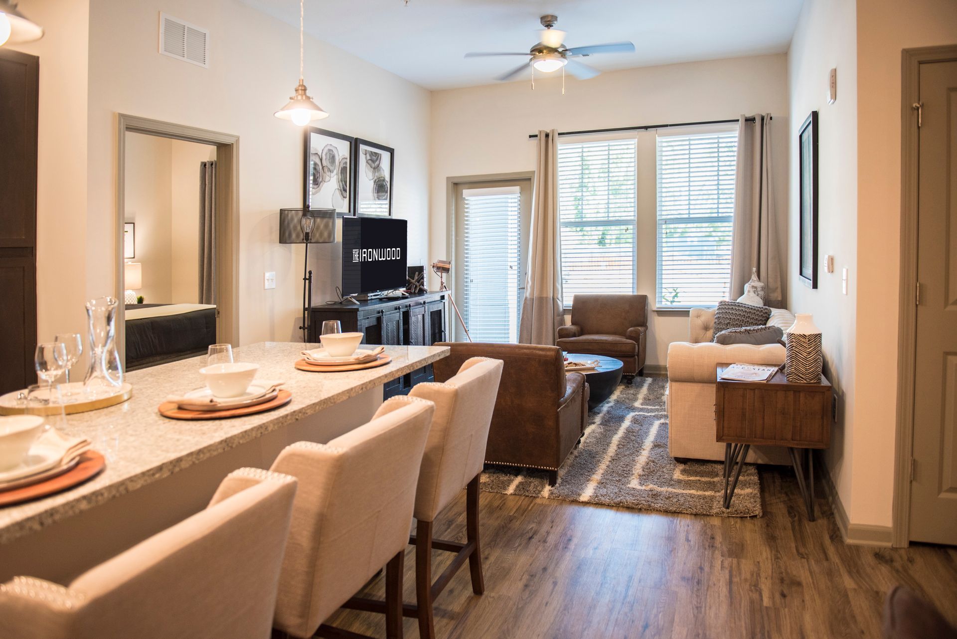 Modern apartment living room with bar seating, neutral tones, and outdoor access.