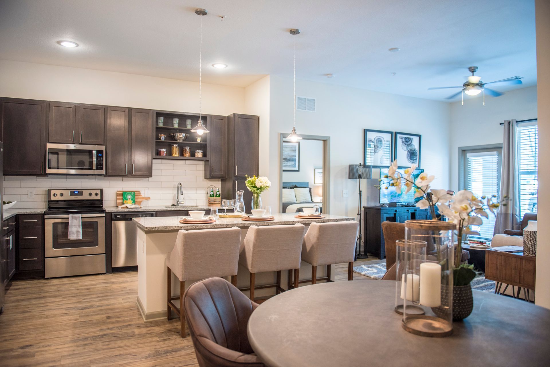 Open kitchen and dining area with dark brown cabinets, a kitchen island, and a table set for eating.