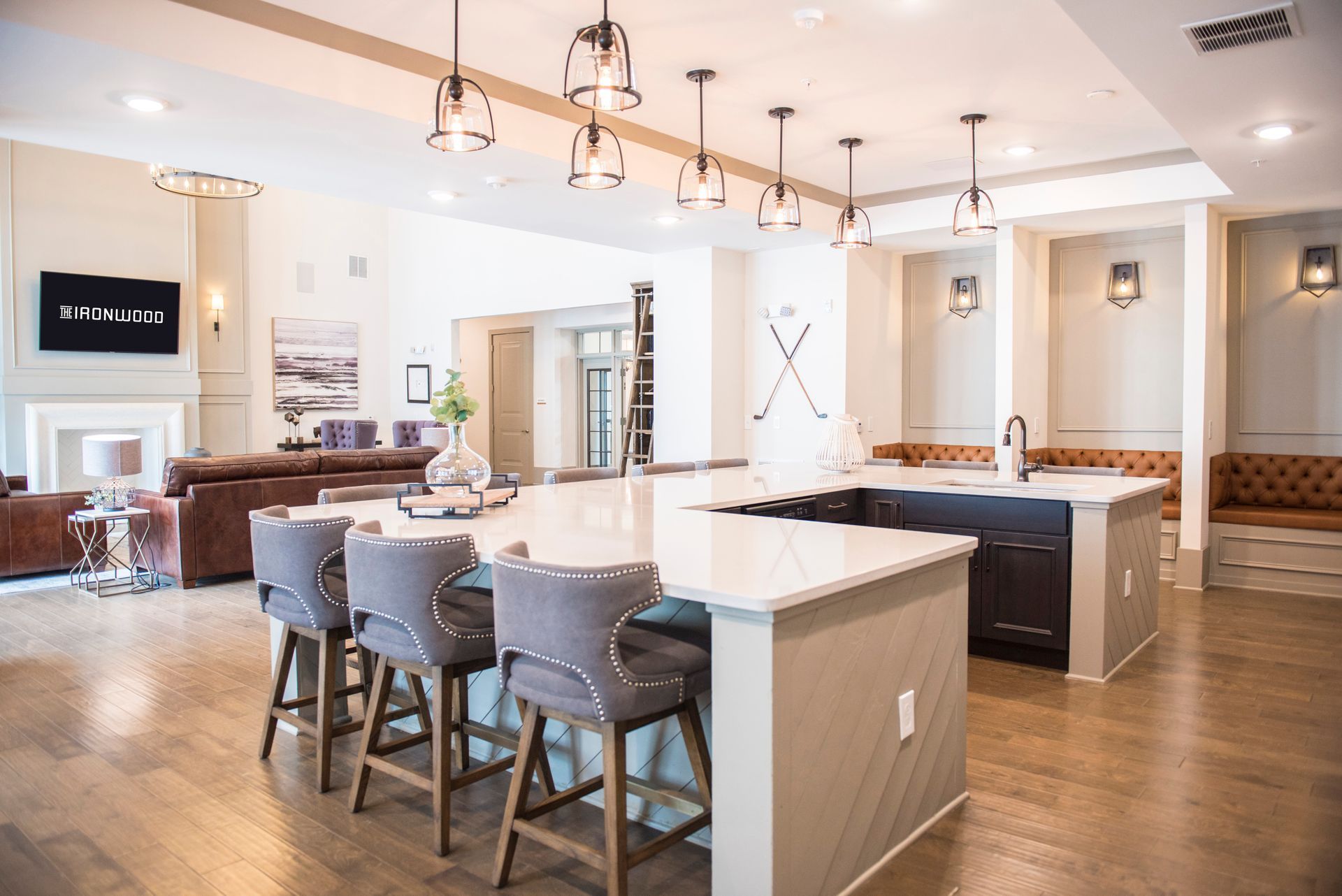 Spacious kitchen with island and bar stools, leading into a living area.