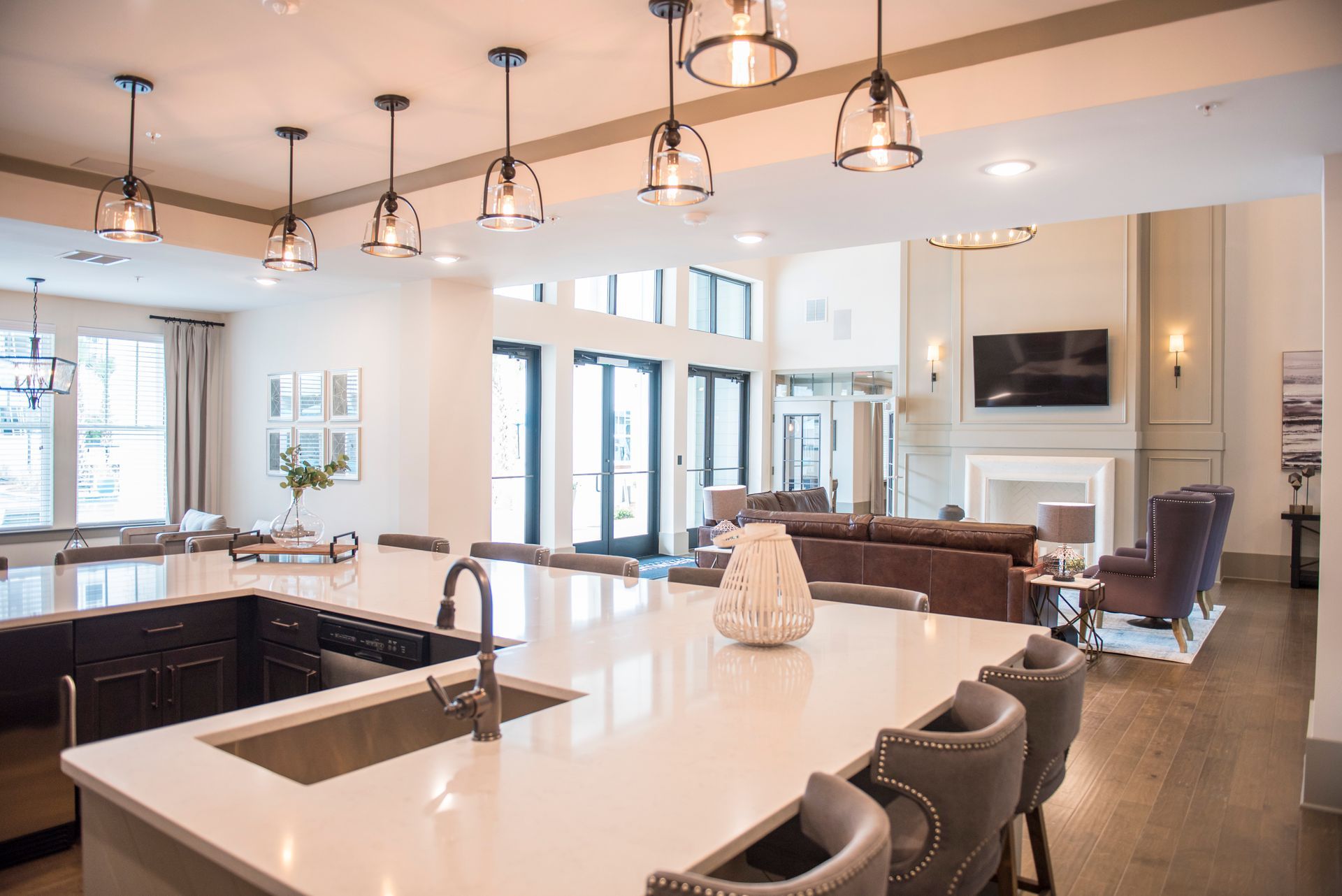 Spacious, modern kitchen with large island and seating, overlooking a living area with fireplace and seating.