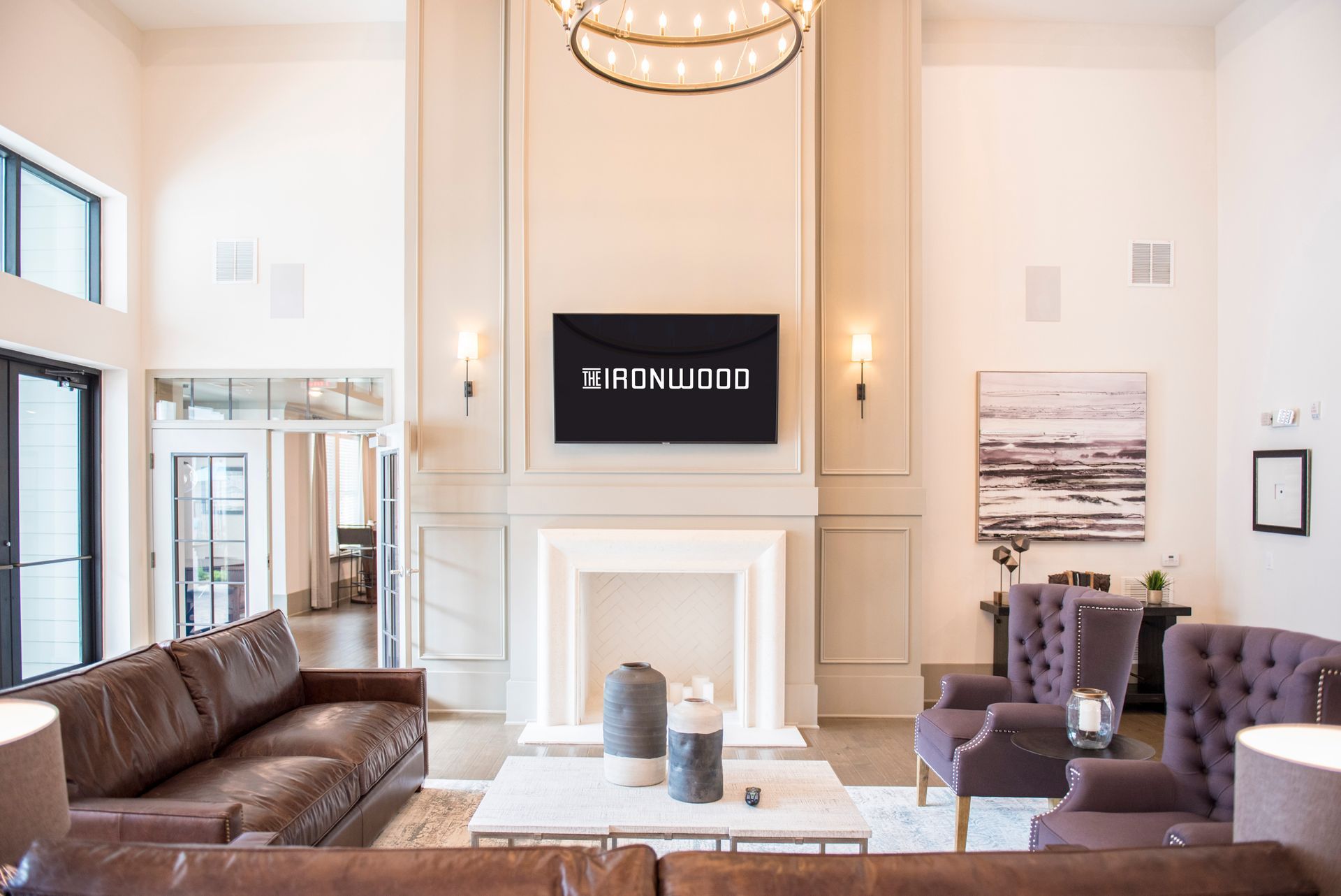A modern living room with leather furniture, a fireplace, and a TV; neutral colors.