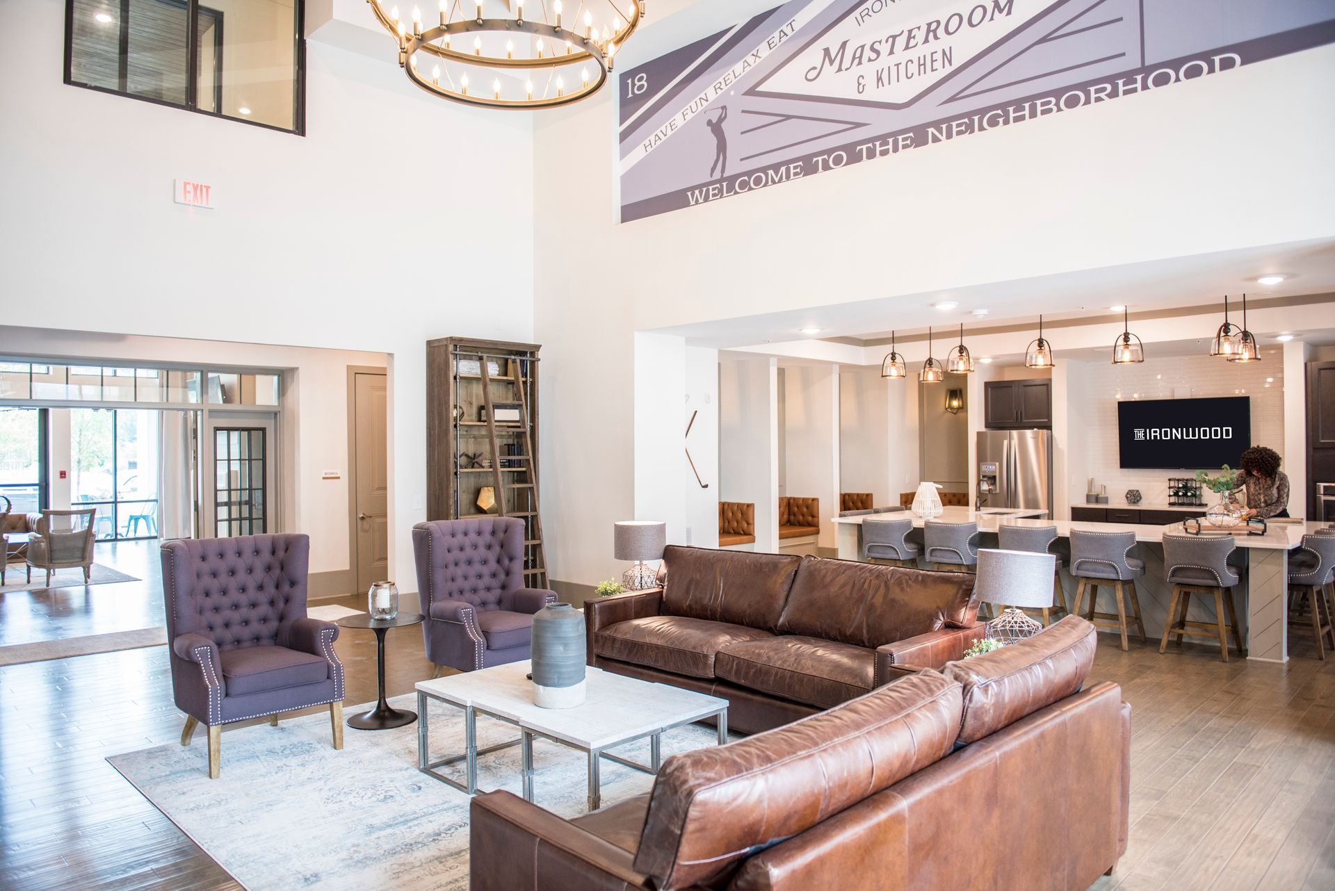 Spacious, well-lit lobby with leather sofas, purple armchairs, and a kitchen area;