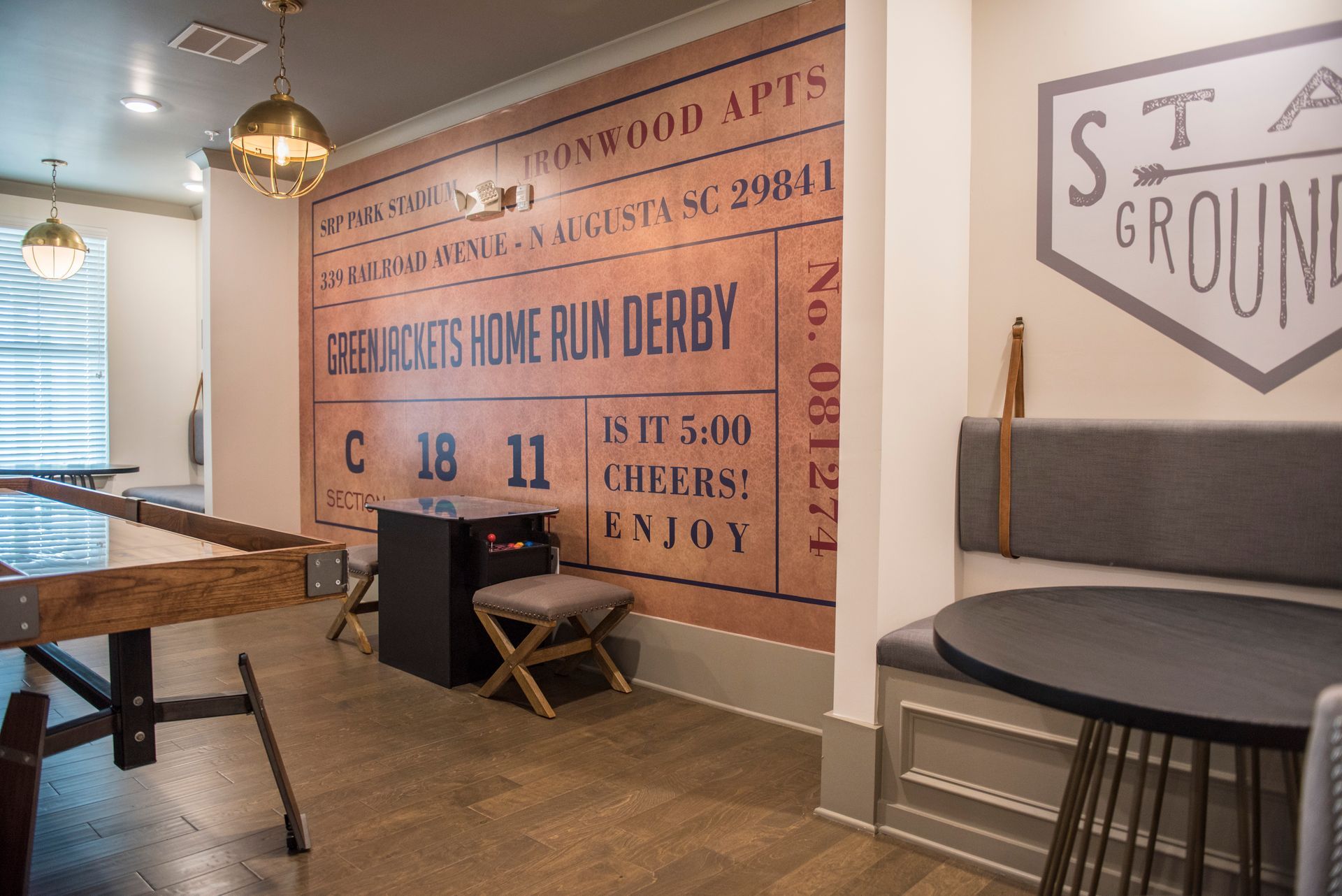 Game room with a foosball table, a wall mural, and seating.