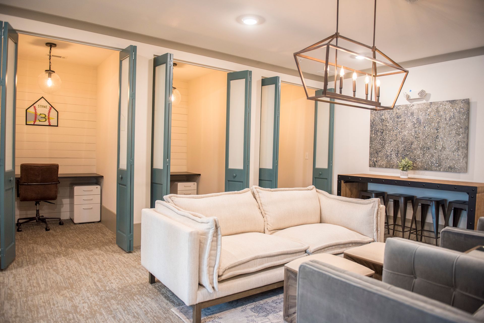 Cozy office with booths, couches, and a large light fixture.