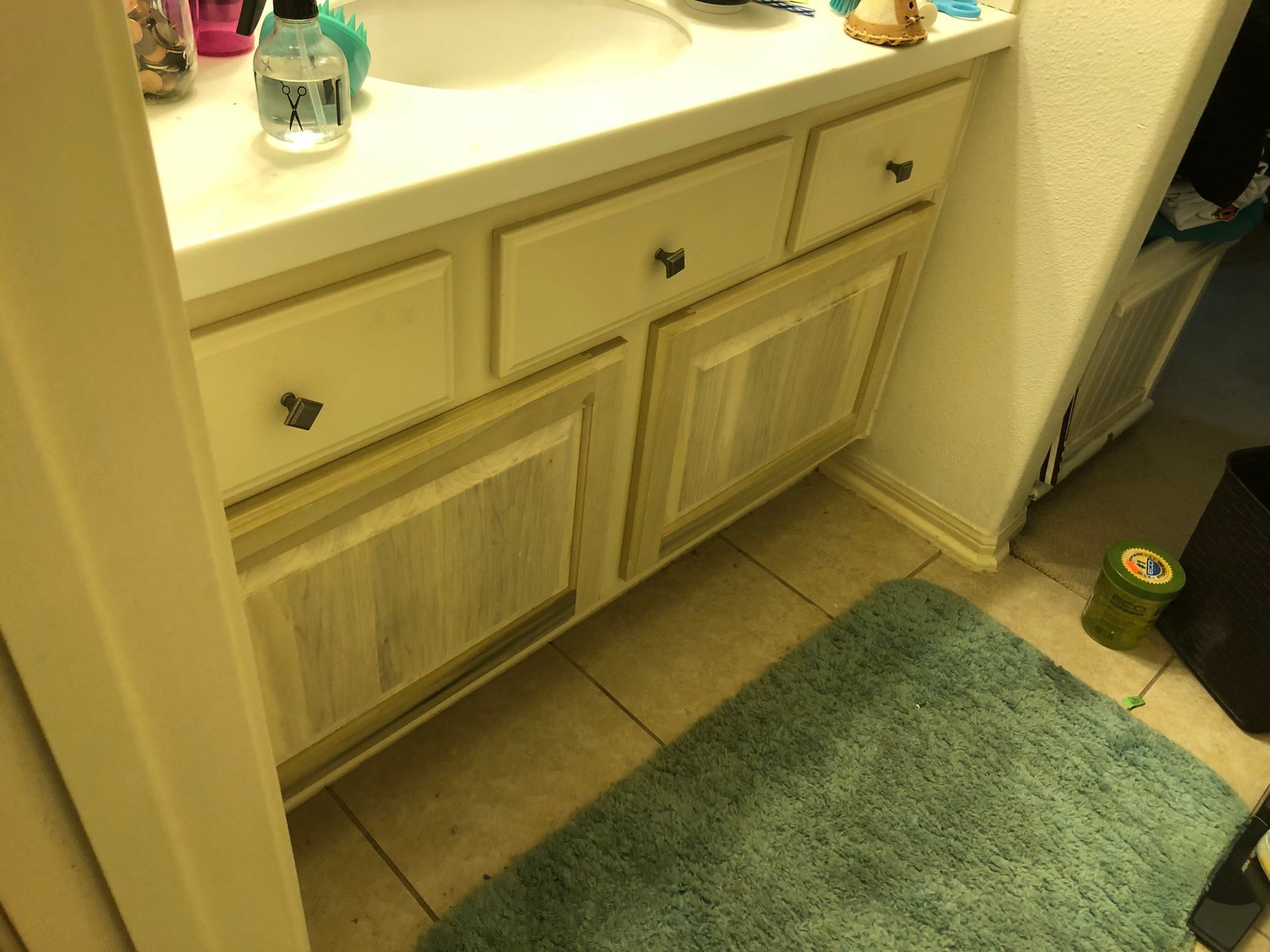 A bathroom vanity with light-colored cabinets and a white countertop, featuring two drawers and two lower doors.