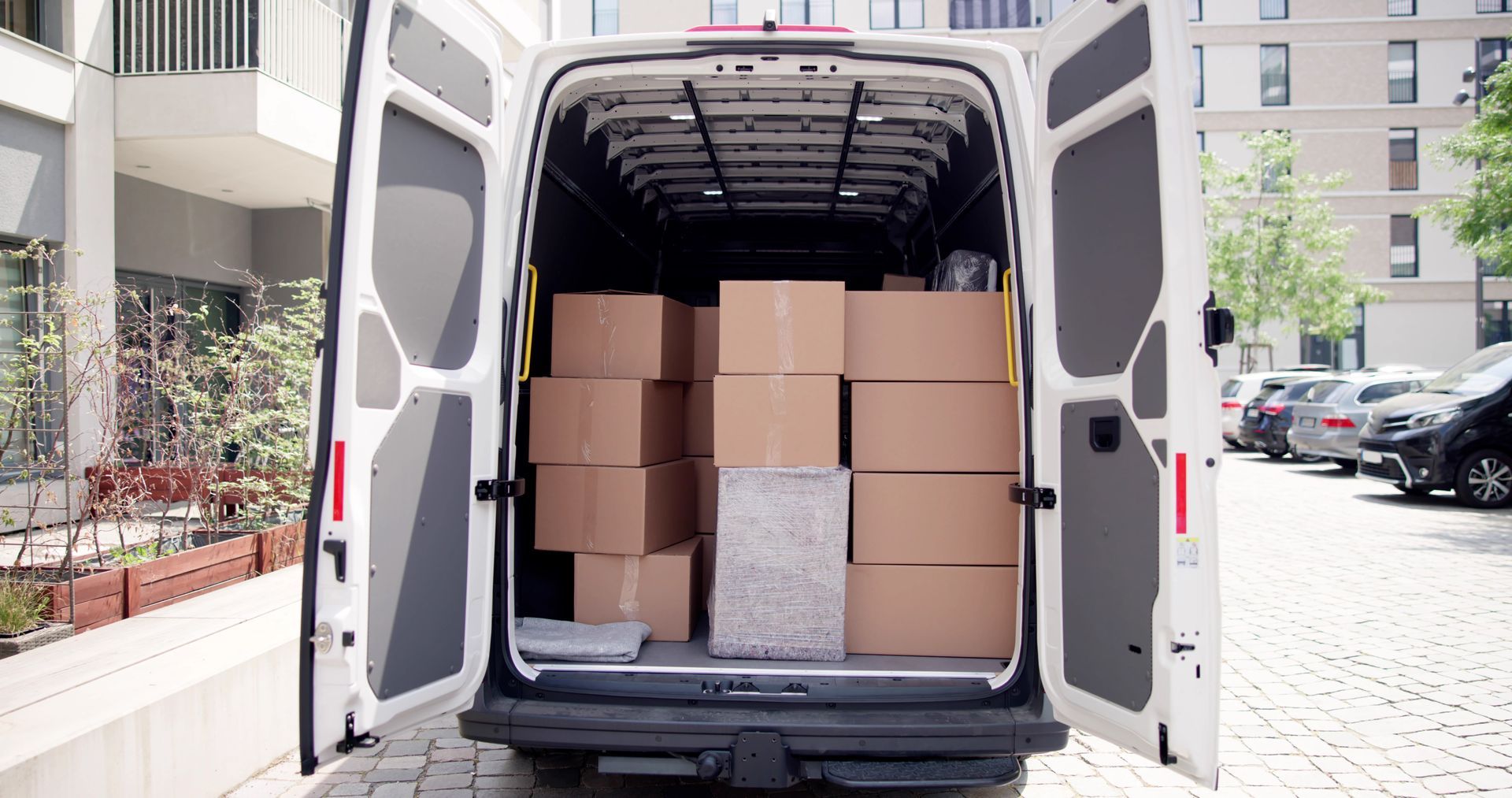 Die Ladefläche eines weißen Lieferwagens ist mit Kisten gefüllt.