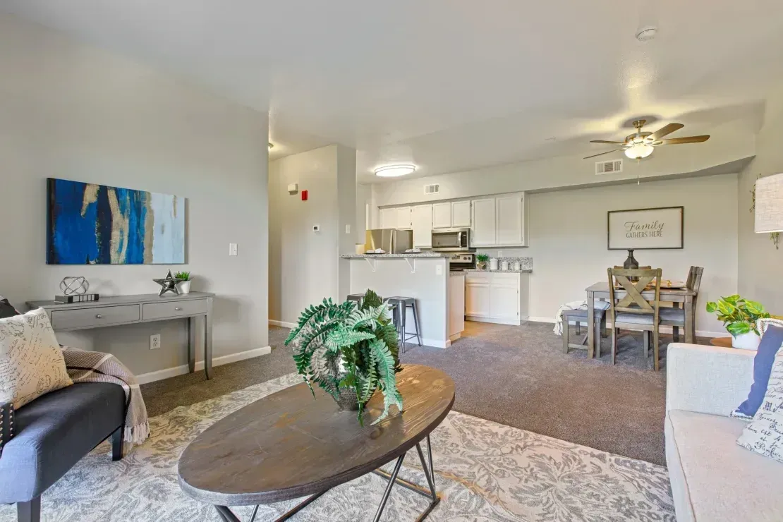 Living room and kitchen area with sofa, coffee table, dining table, and bar seating.