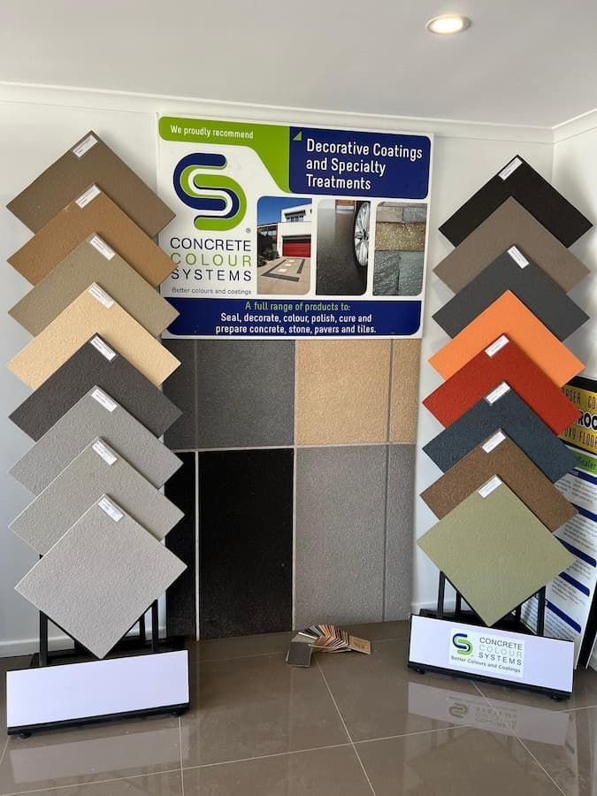 A Display of Tiles and a Sign That Says Concrete Colour Systems — Fraser Coast Waterproofing in Pialba, QLD