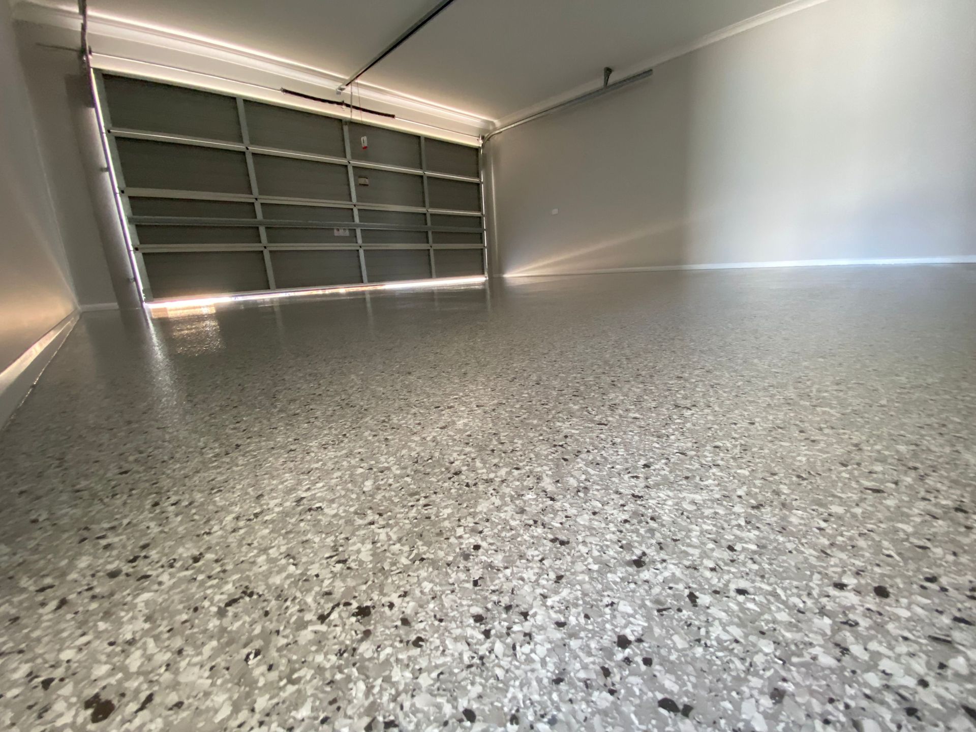 A Paint Roller Is Laying on A Concrete Floor — Fraser Coast Waterproofing in Pialba, QLD