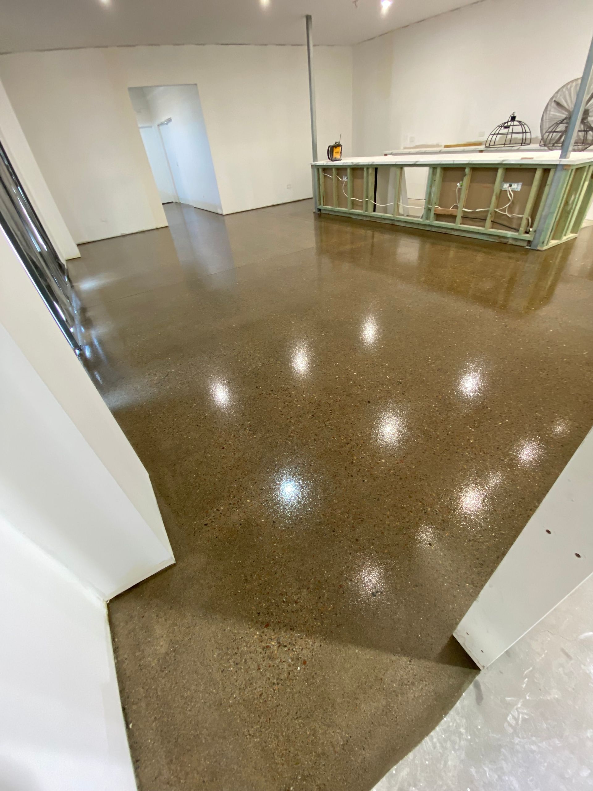A Man Is Plastering a Wall with A Trowel — Fraser Coast Waterproofing in Pialba, QLD