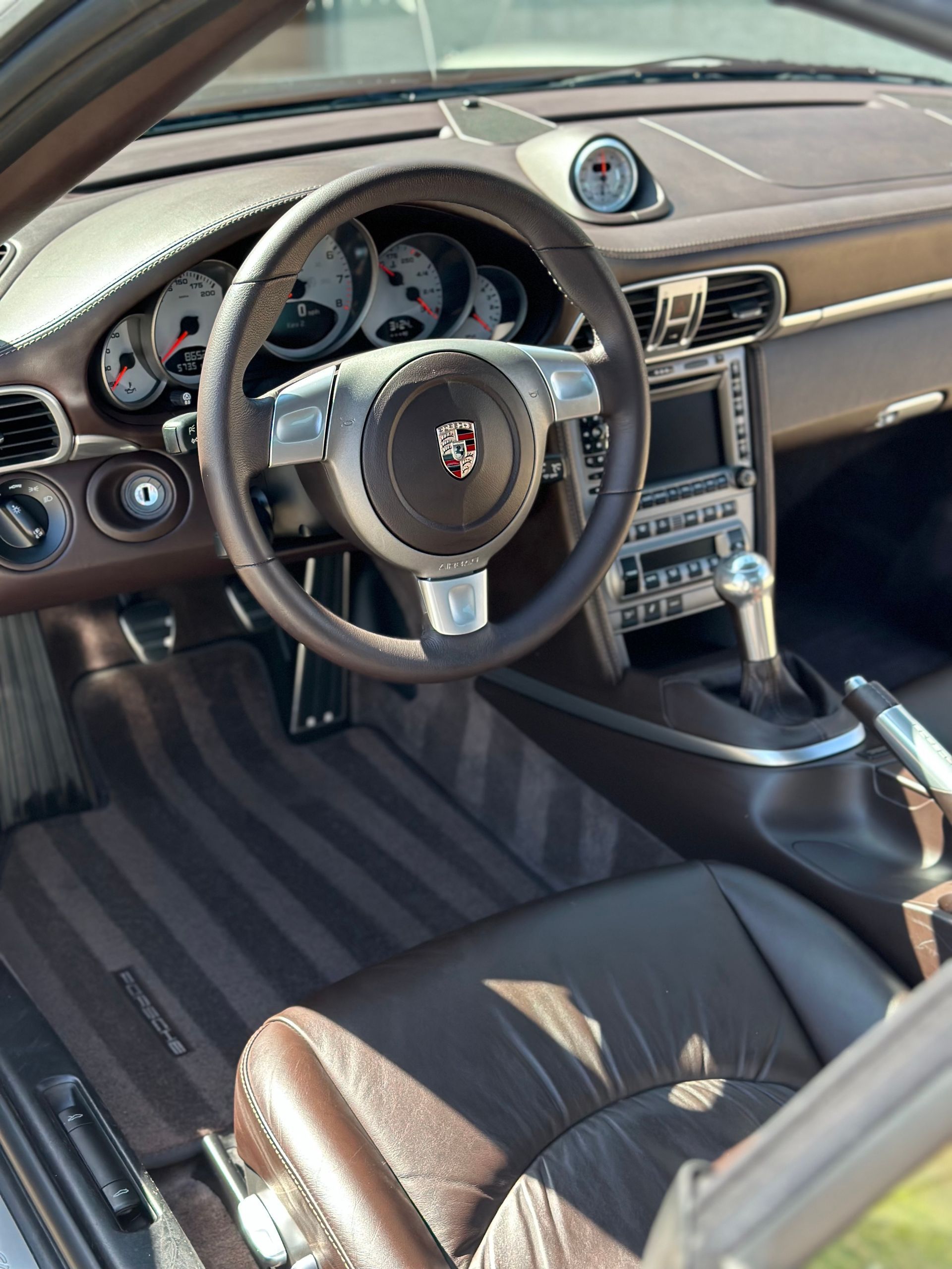 The interior of a porsche with a steering wheel