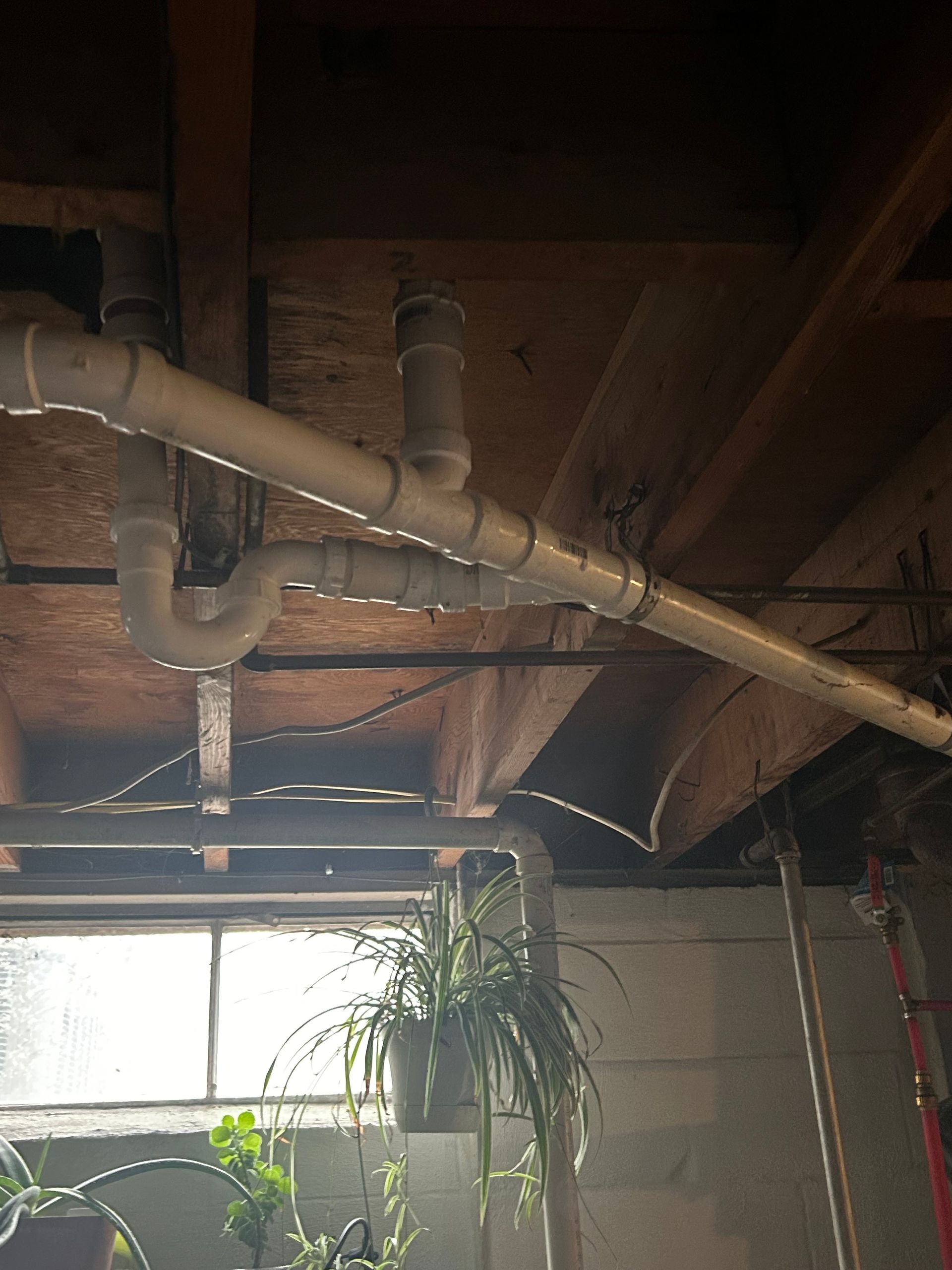 A ceiling with a lot of pipes hanging from it