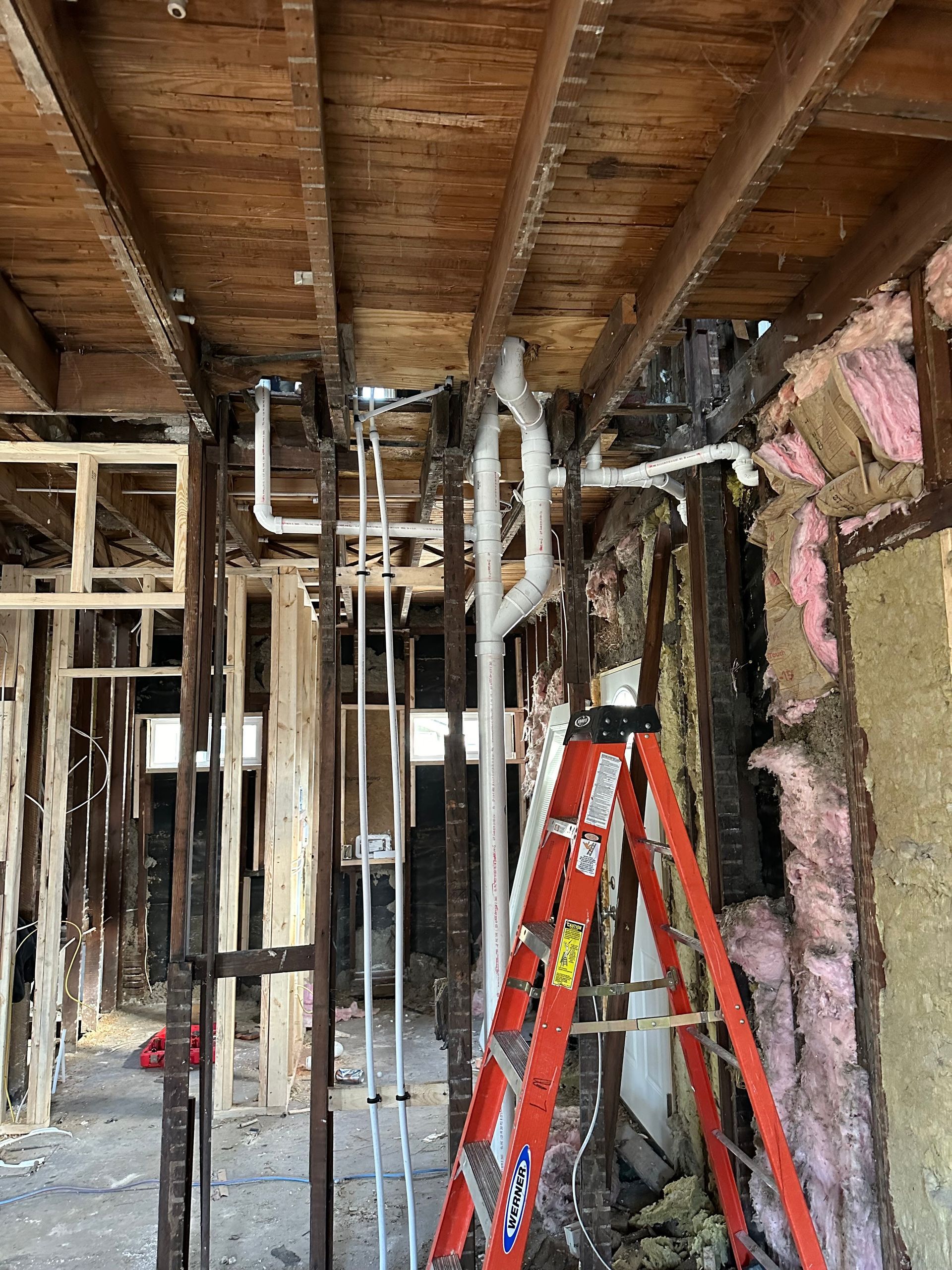 A ladder is sitting in the middle of a building under construction.
