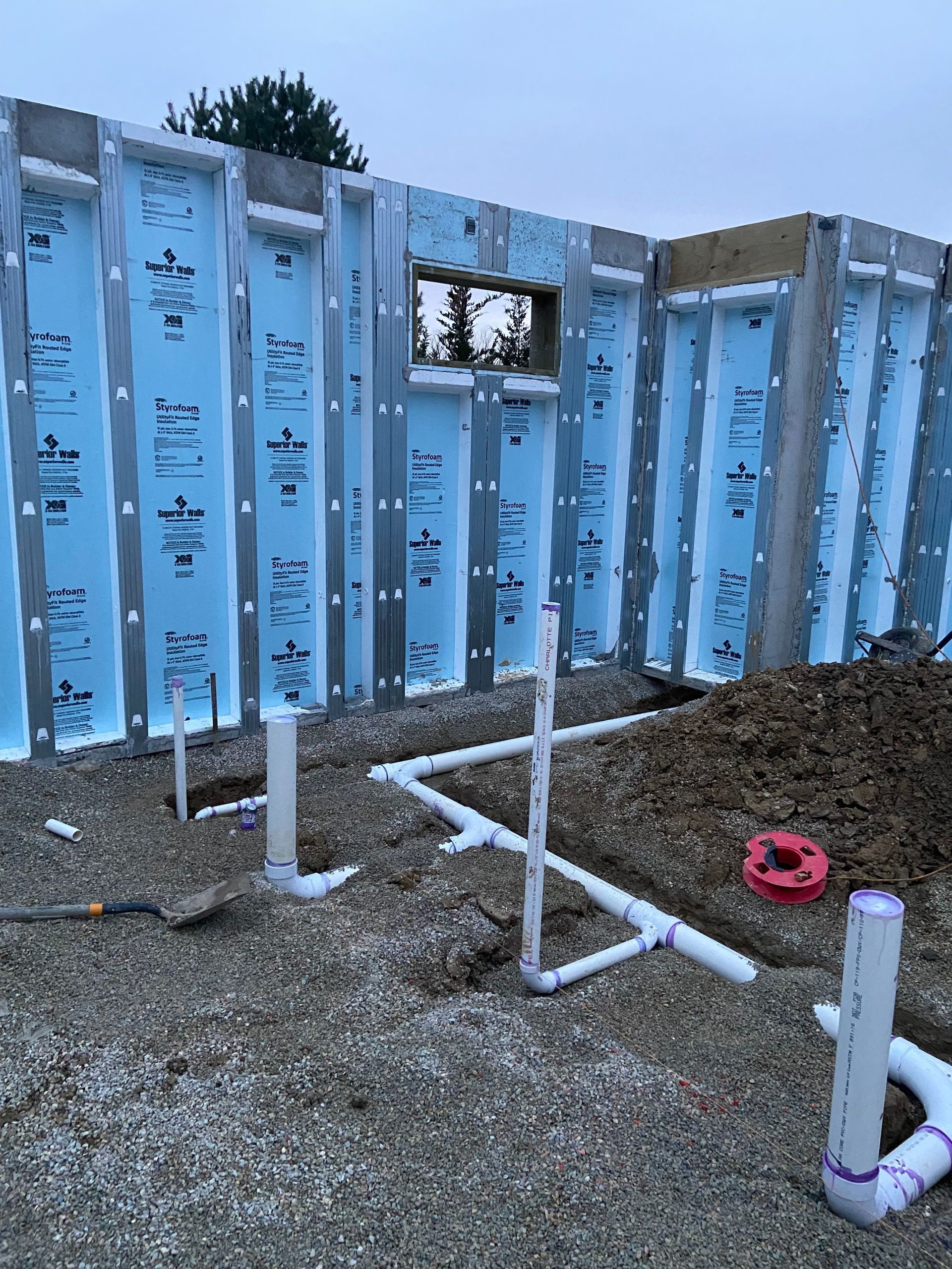 A building under construction with a lot of pipes and a window.