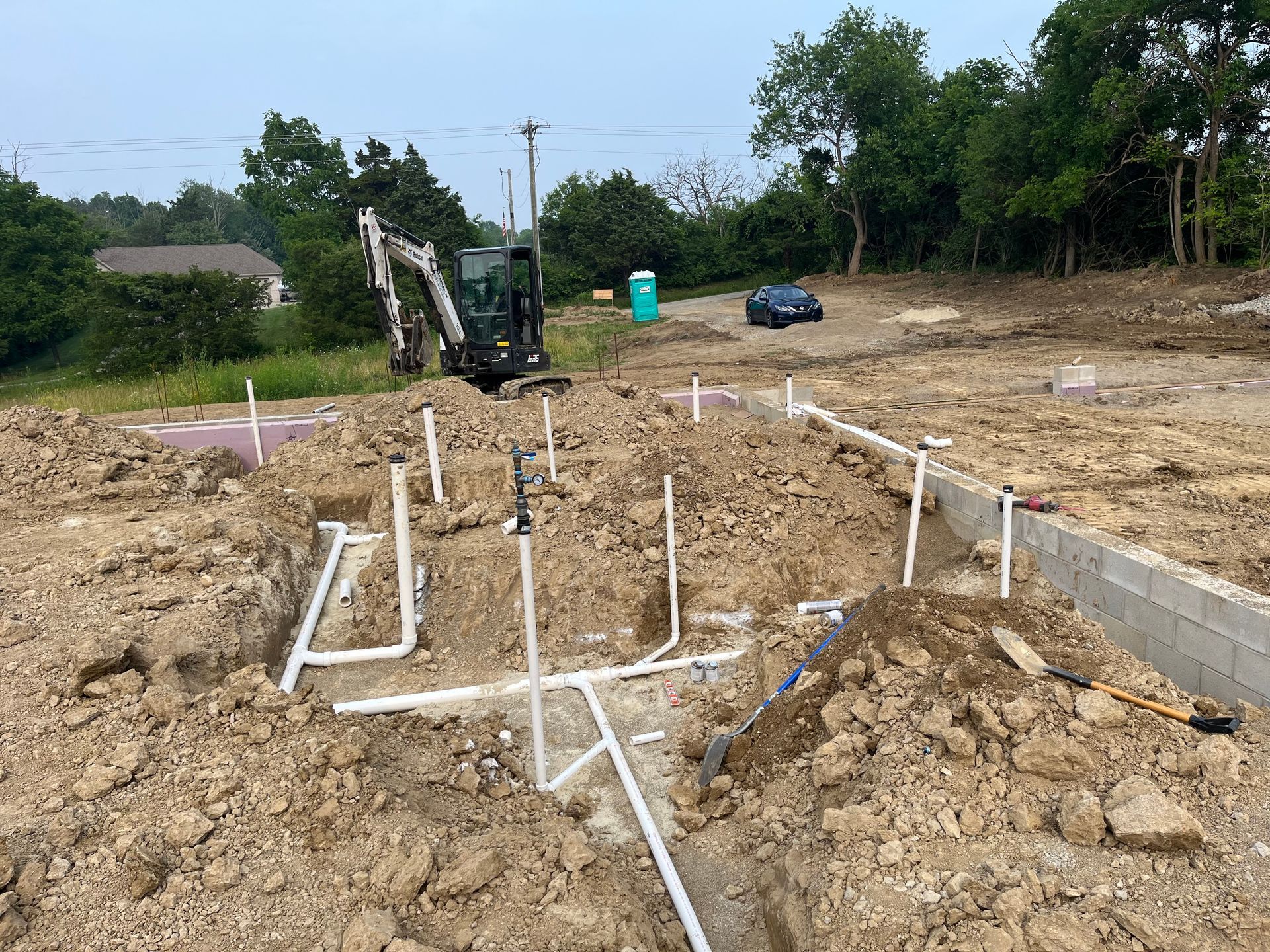 A construction site with a lot of dirt and pipes in the ground.