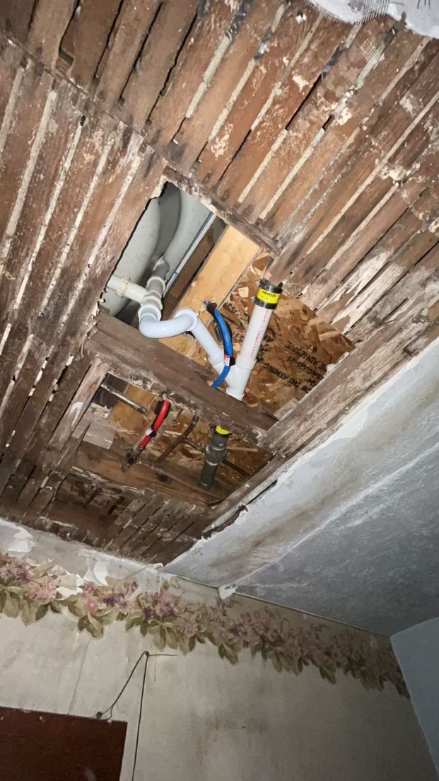 A bathroom sink is being installed in a hole in the ceiling.