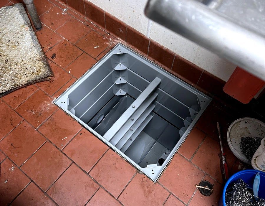 A metal box is sitting on a tiled floor.