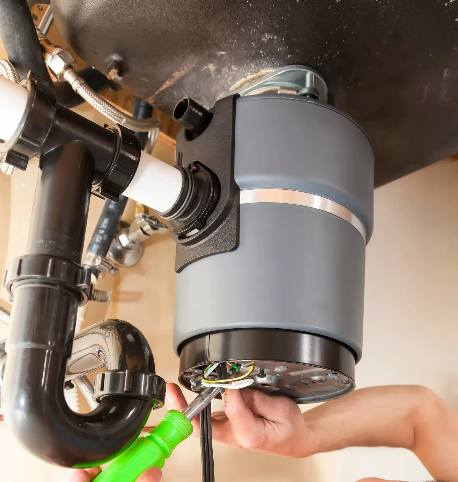 A man is fixing a sink in a bathroom.