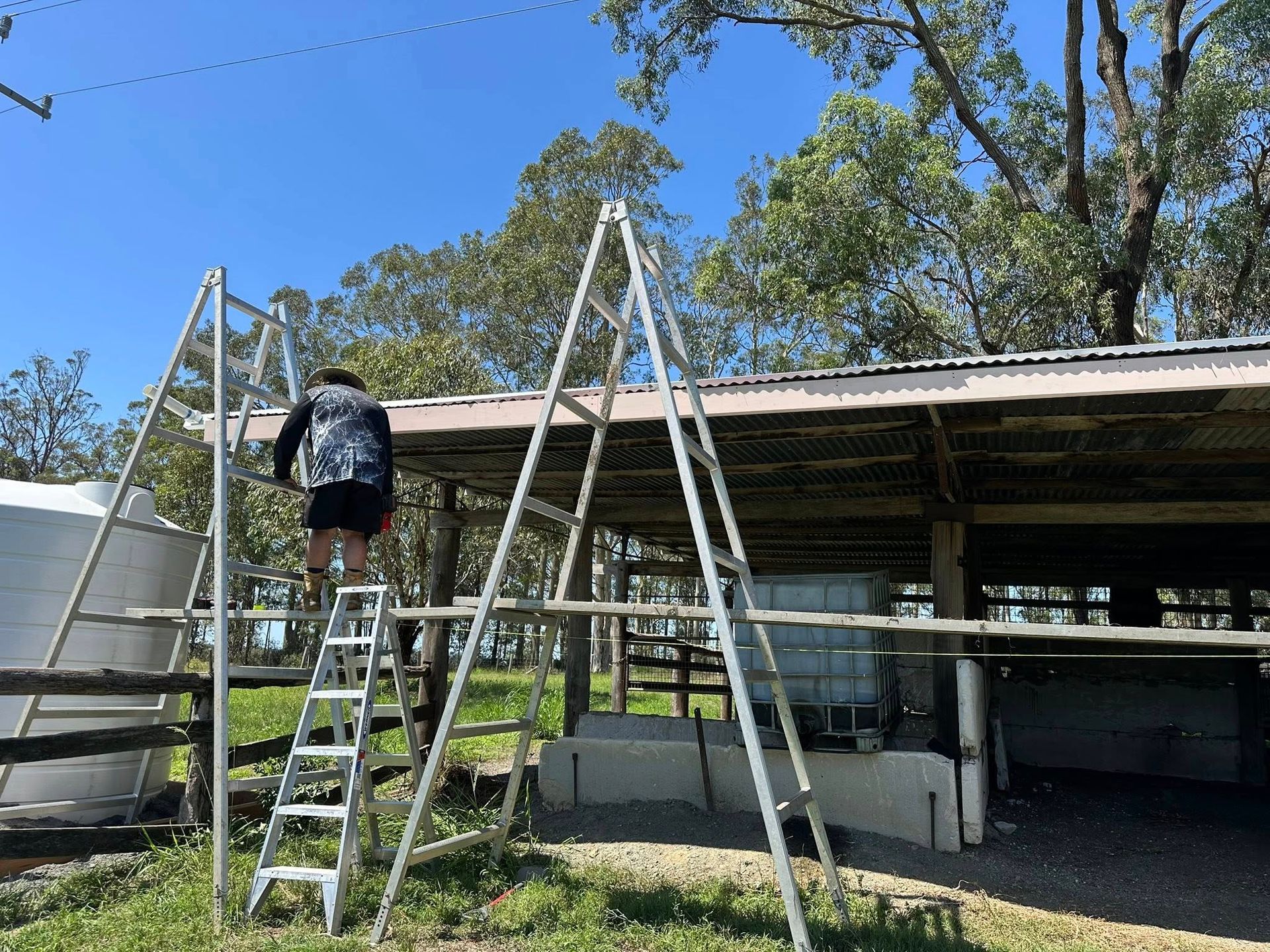 Person on a Ladder Near a Shed — Chris Murphy Plumbing & Maintenance In Langley Vale, NSW