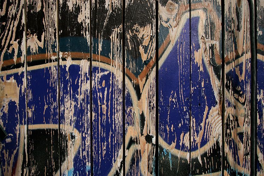 A close up of a wooden wall with graffiti on it